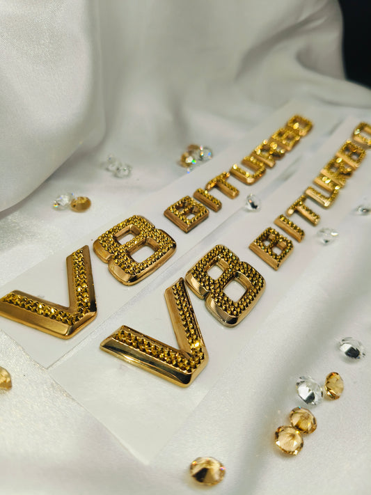 Original OEM | Mercedes-Benz AMG V8 Biturbo Gold 24k Logo Emblem Set 2 Stück | mit original Preciosa® Kristallen - Black Saphir Crystals