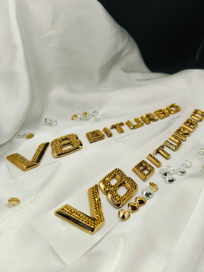 Original OEM | Mercedes-Benz AMG V8 Biturbo Gold 24k Logo Emblem Set 2 Stück | mit original Preciosa® Kristallen - Black Saphir Crystals